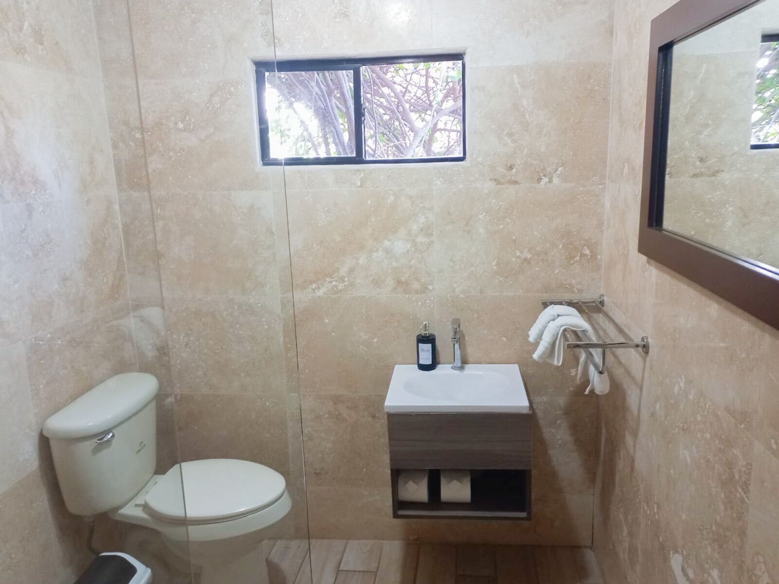 Un baño pequeño con inodoro, lavamanos y ventana.