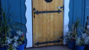 A wooden door with the name 'CARLIS' and two arrows pointing in opposite directions. - Carla's Inn (Baraga)