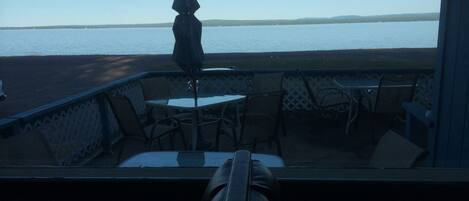 Un patio con mesa y sillas, con vista a un cuerpo de agua.