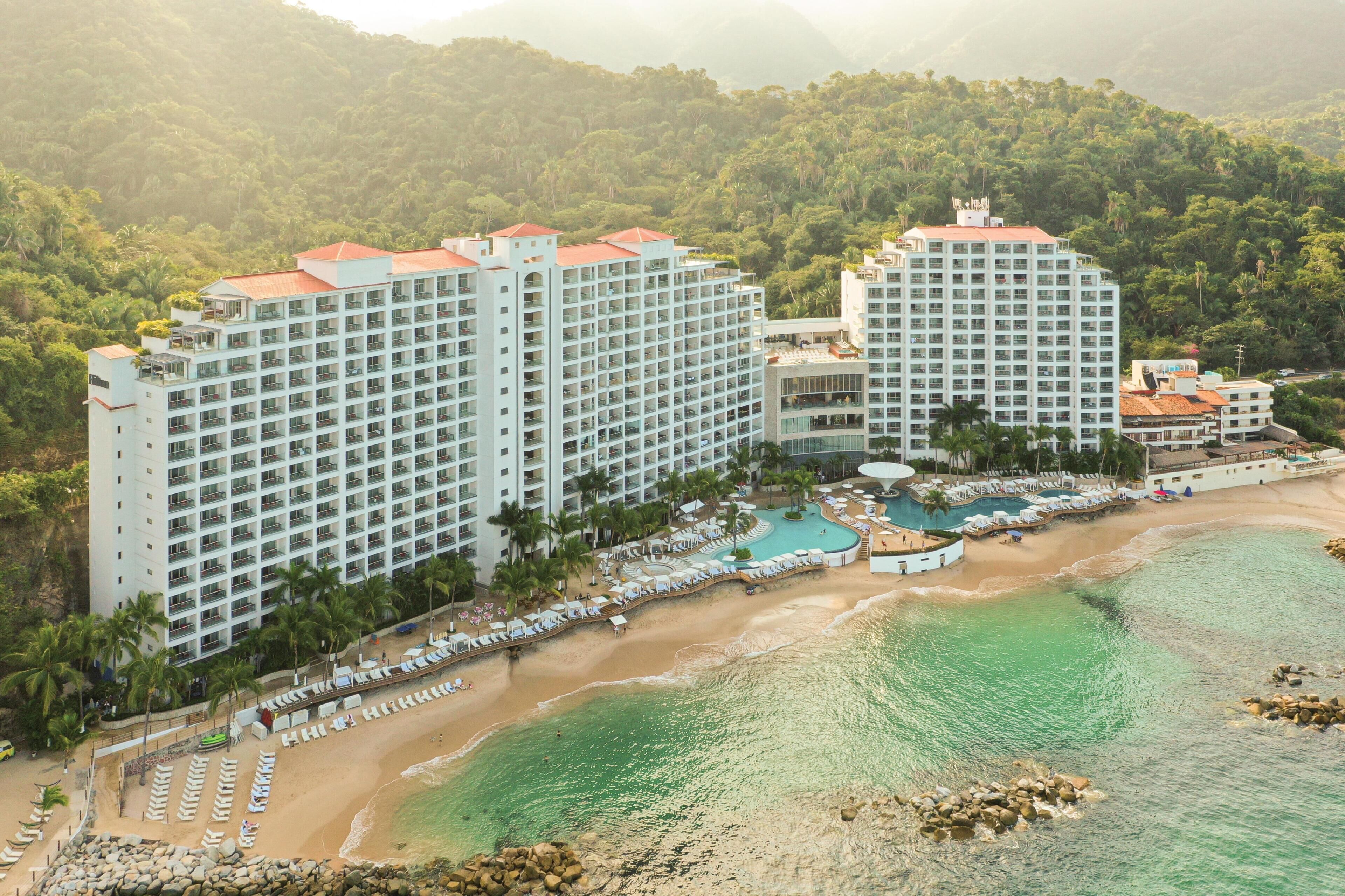 A resort with multiple high-rise buildings, a beach, and a pool area.