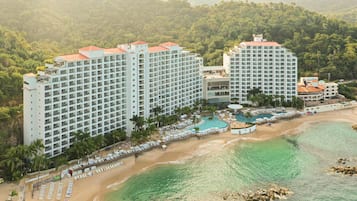 A resort with multiple high-rise buildings, a beach, and a pool area.