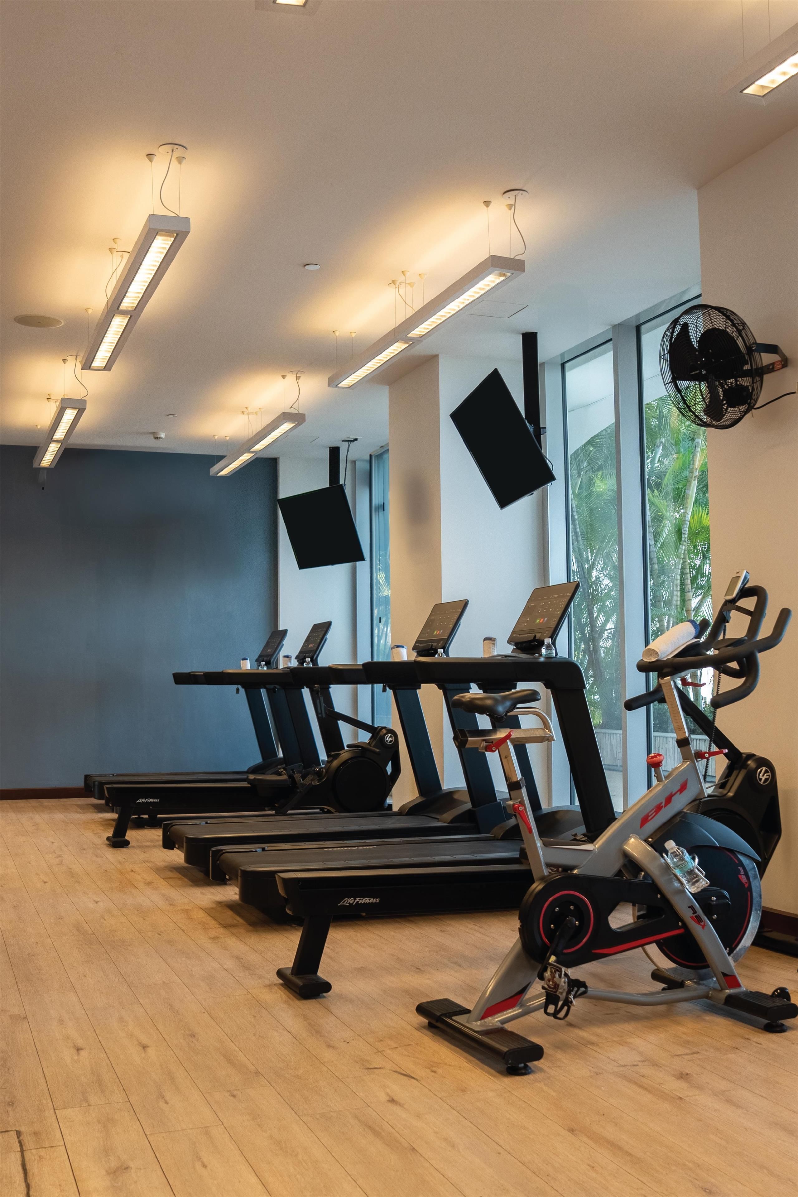 A gym with treadmills, an elliptical, and a stationary bike.