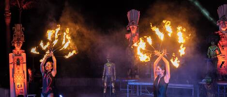 A performance with fire props and performers in costumes.