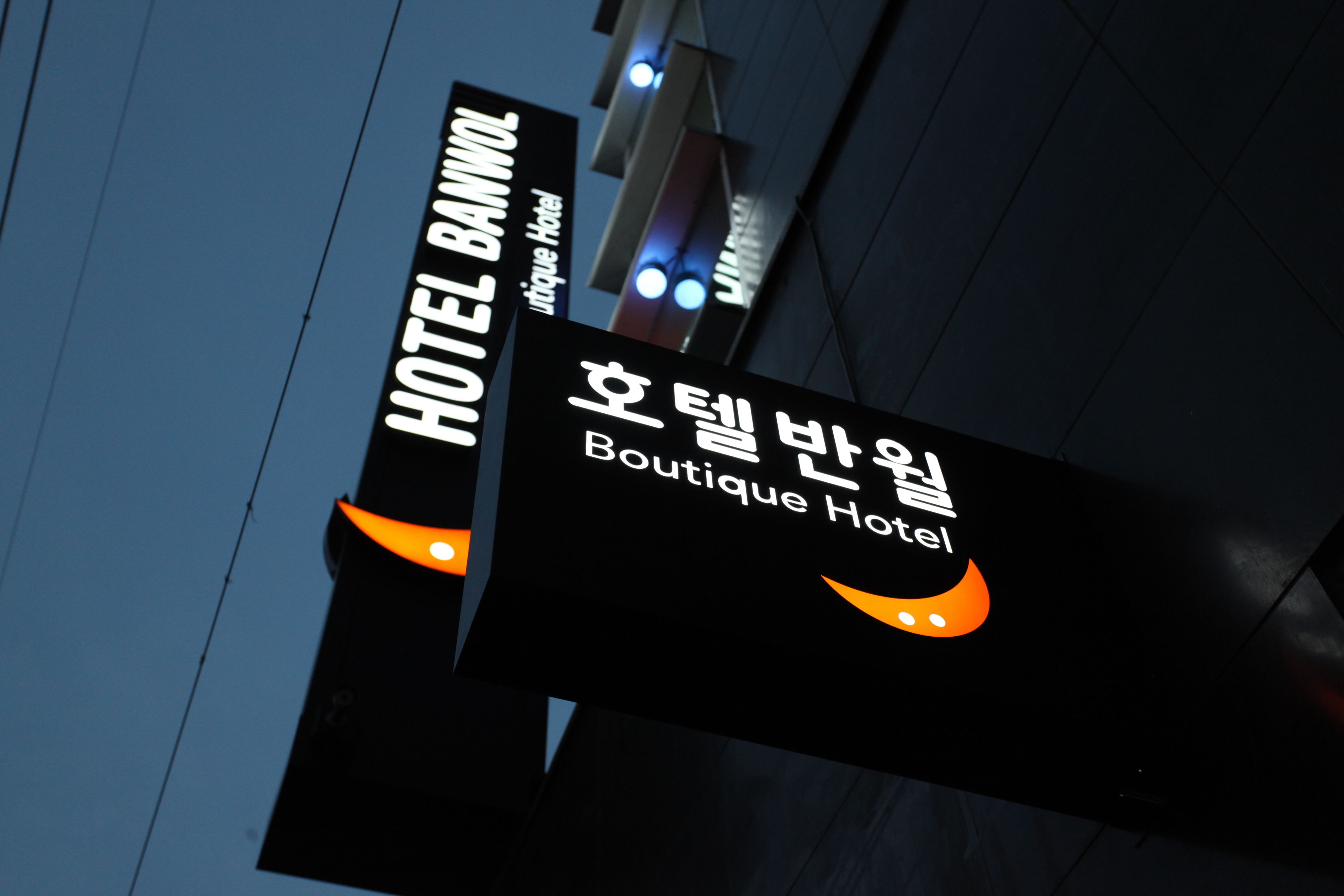 Un letrero para Boutique Hotel, con texto coreano y un logotipo estilizado.