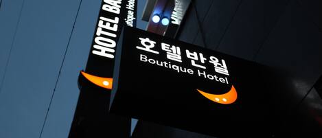 Un letrero para Boutique Hotel, con texto coreano y un logotipo estilizado.