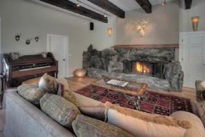 A cozy living room with a stone fireplace, a sofa, and a coffee table.