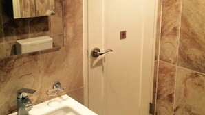 A bathroom with a white sink, a mirror, and a door.