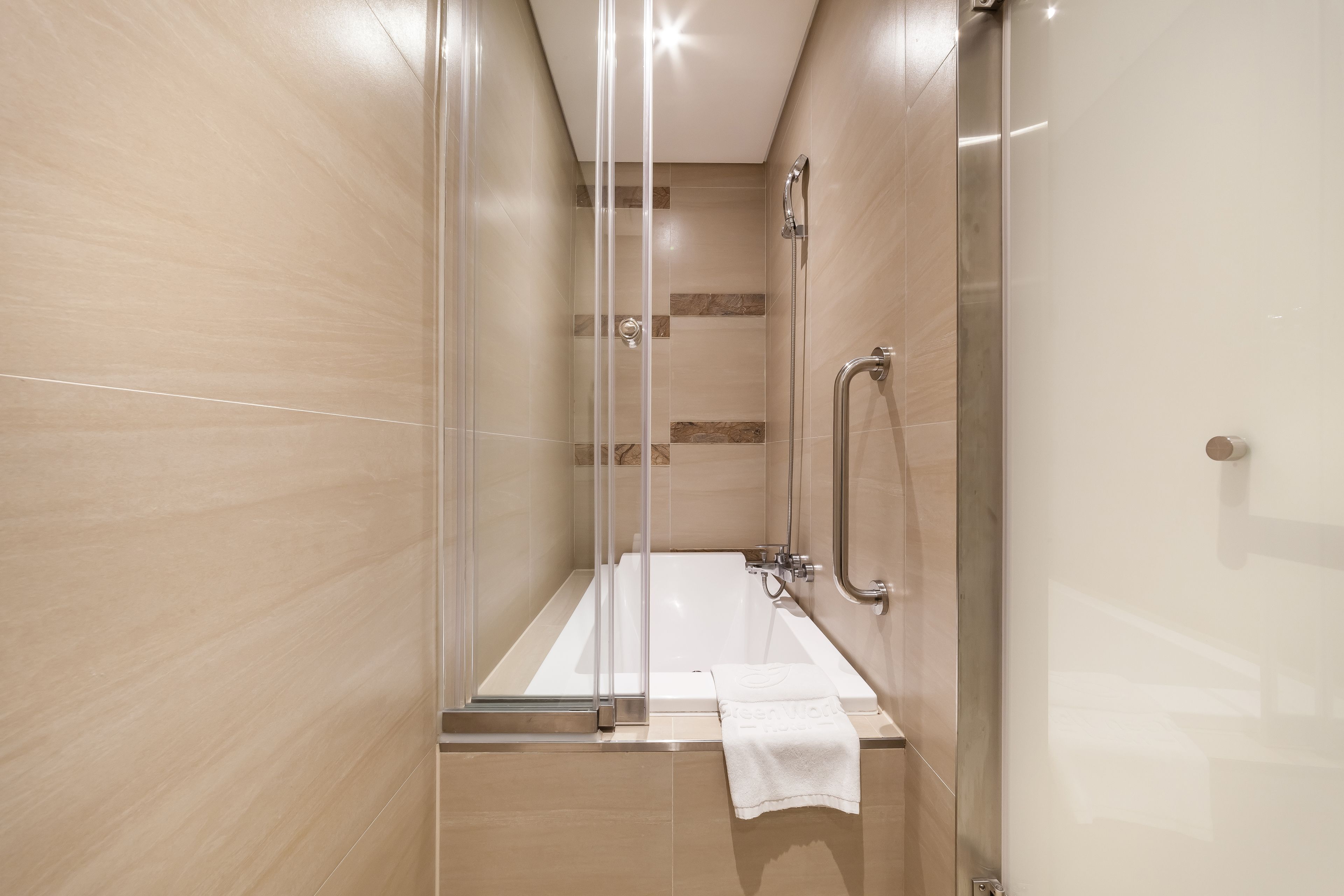 A modern bathroom with a glass-enclosed shower, a standalone bathtub, and a glass door.