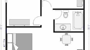 A floor plan of a Four Queen Room with a large bed, a separate bathroom, a small kitchen, and a dining area. - City Center Motel (West Yellowstone)