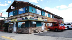 A two-story motel with a wooden facade and large windows. - City Center Motel (West Yellowstone)