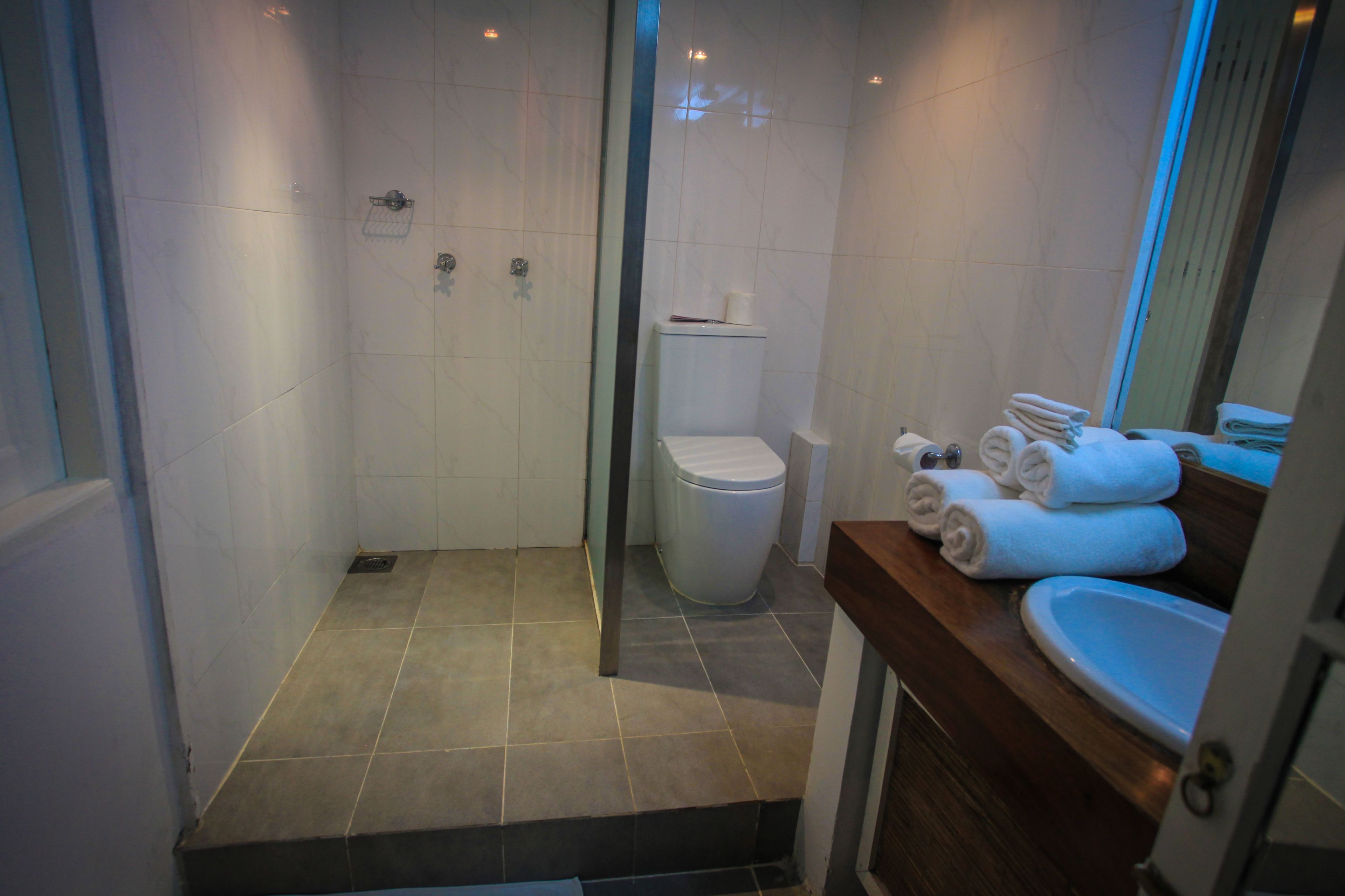 A bathroom with a shower, toilet, and sink.