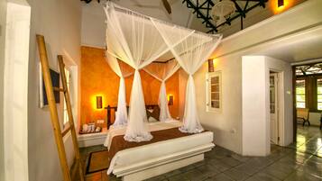 A bedroom with a four-poster canopy bed, a wooden ladder, and a tiled floor.
