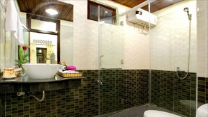 A bathroom with a glass-enclosed shower, a white toilet, and a sink with a mirror. - Bamboo Garden Homestay (Da Nang)