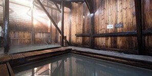 A traditional wooden bathhouse with a hot spring, wooden walls, and a sign indicating the room number. - Yachi Onsen Spa (Towada)