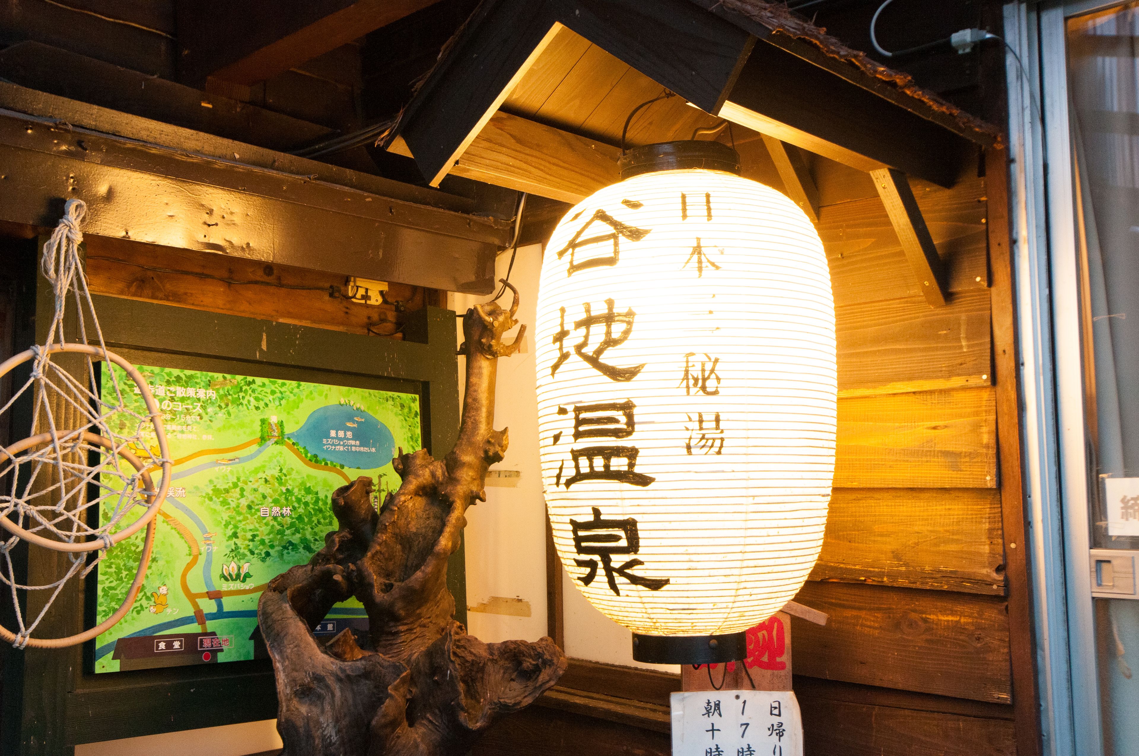A traditional Japanese lantern with Japanese characters, a wooden interior, and a digital map display.