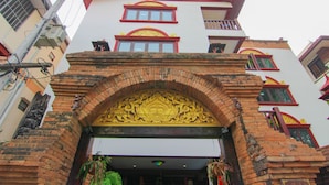 A multi-story building with a traditional architectural style, featuring a prominent entrance with ornate brickwork and a decorative archway.