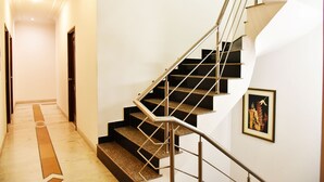 A modern staircase with metal railings and a carpeted landing. - Hotel Sapphire (Amritsar)