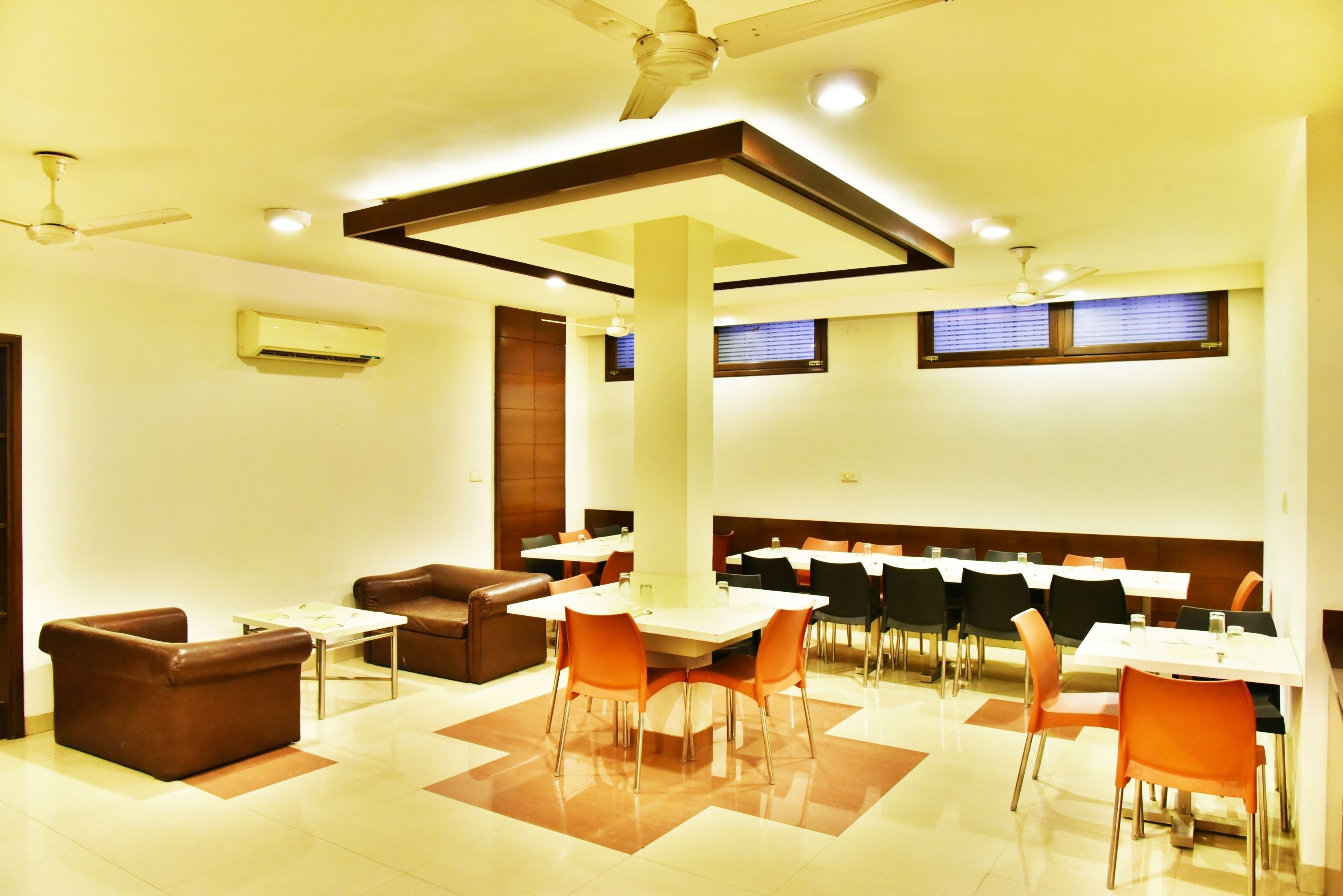 A dining area with tables and chairs, a ceiling fan, and an air conditioning unit.