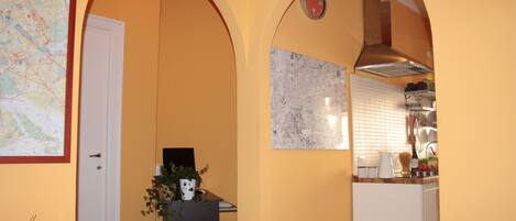 A kitchen with white cabinets, a map on the wall, and a clock.