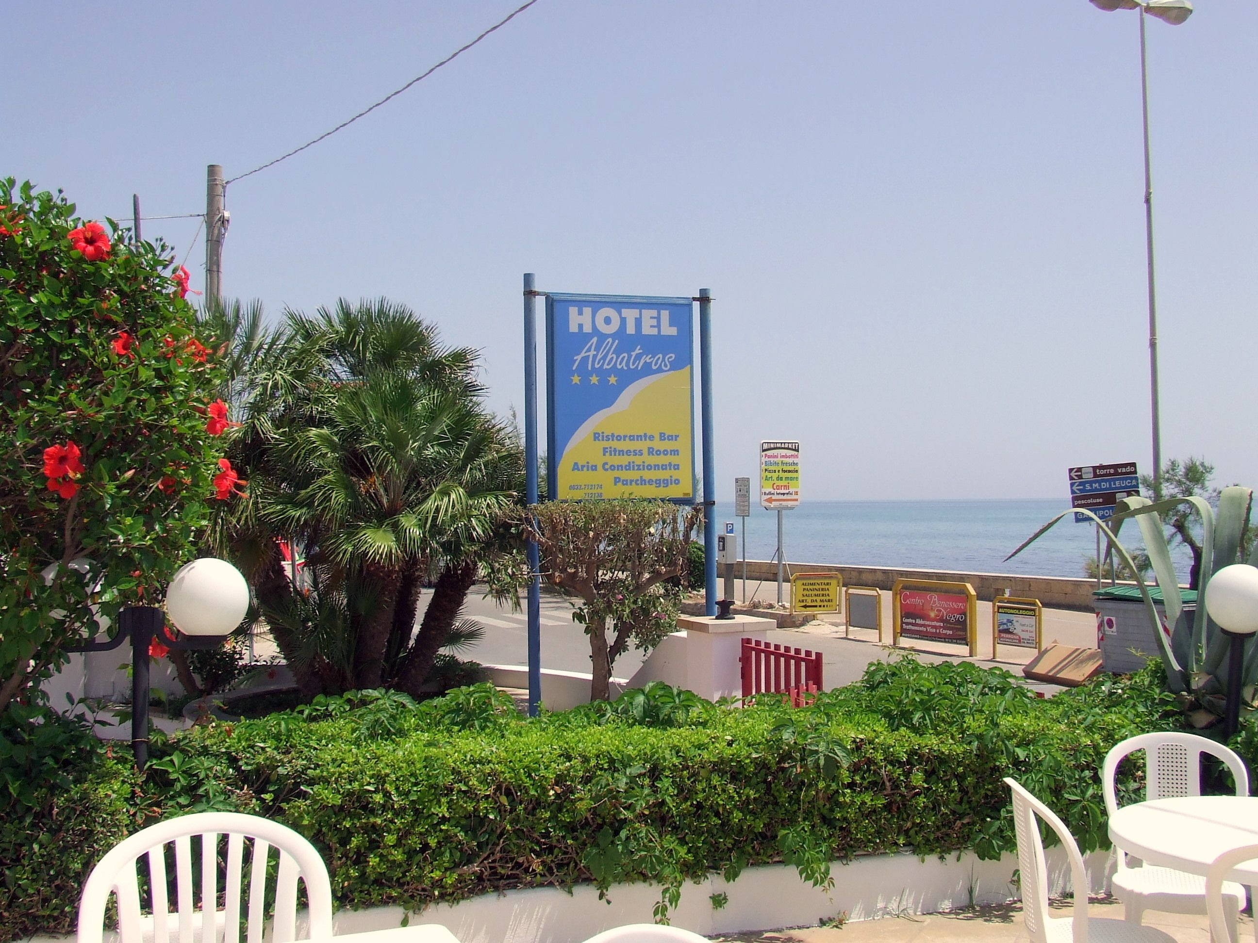 Un panneau indiquant la présence d’un hôtel offrant divers services, notamment un restaurant, une salle de sport et une piscine.