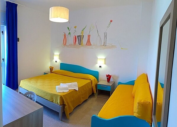 A hotel room with two beds, a desk, a chair, a nightstand, a lamp, and a wall with a floral painting.