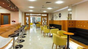 A modern hotel lobby with a bar area, yellow chairs, and a black sofa. - Hotel Tomislavov Dom (Zagreb)