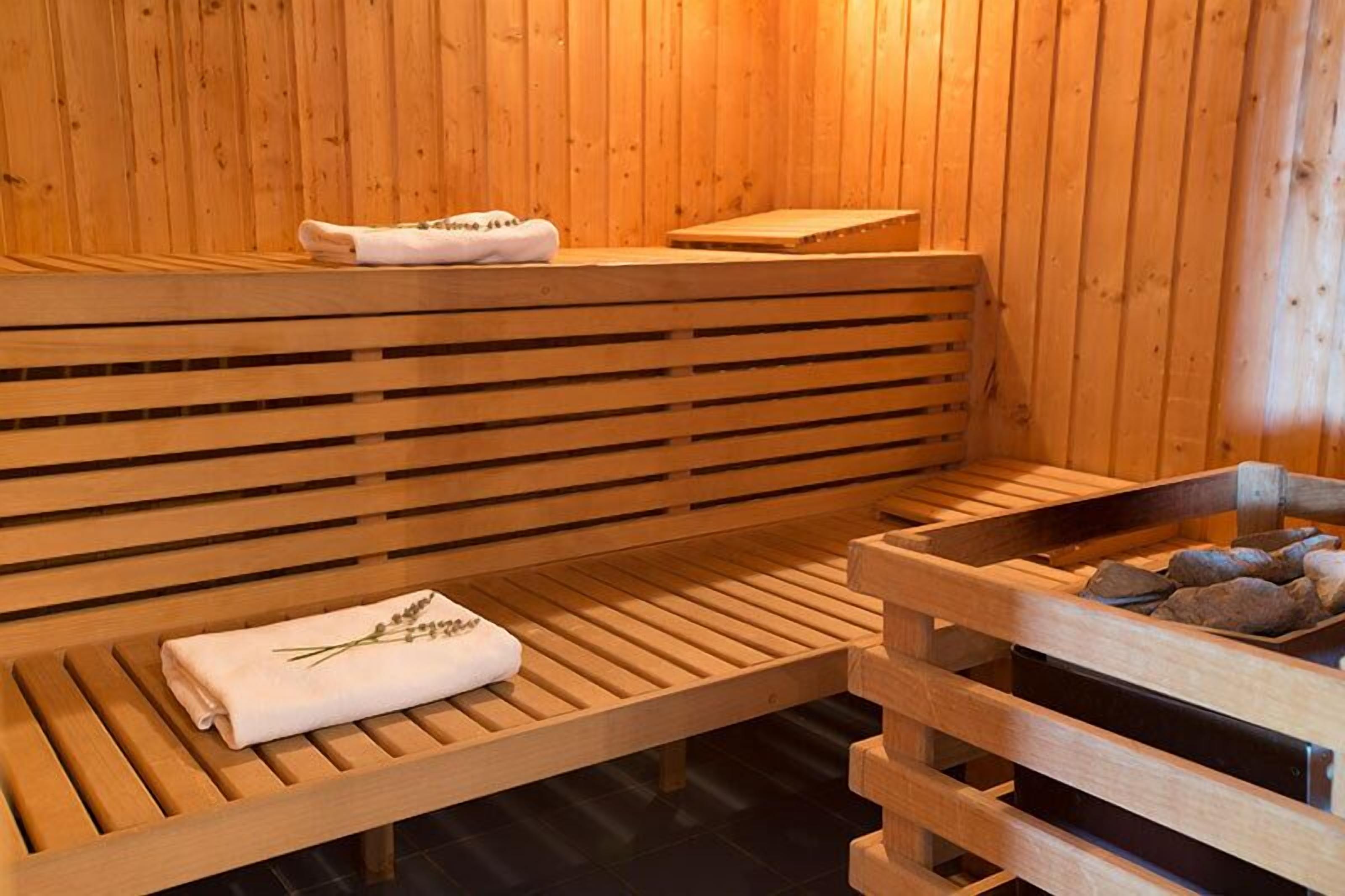 A wooden sauna with benches and a stone basin.