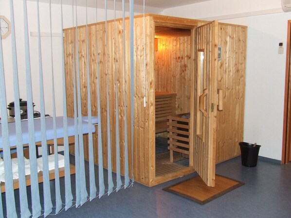 A sauna room with a wooden door, a bench, and a small table with a kettle. - Hotel Tomislavov Dom (Zagreb)