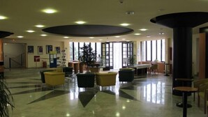A spacious lobby with a high ceiling, large windows, and a central plant. - Hotel Tomislavov Dom (Zagreb)