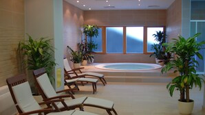A spa area with a hot tub, lounge chairs, and potted plants. - Aparthotel Snjezna Kraljica (Stubicke Toplice)