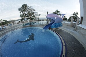 Une piscine ornée d’une grande sculpture de baleine.