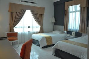 Une chambre d’hôtel avec deux lits, un bureau et une chaise.
