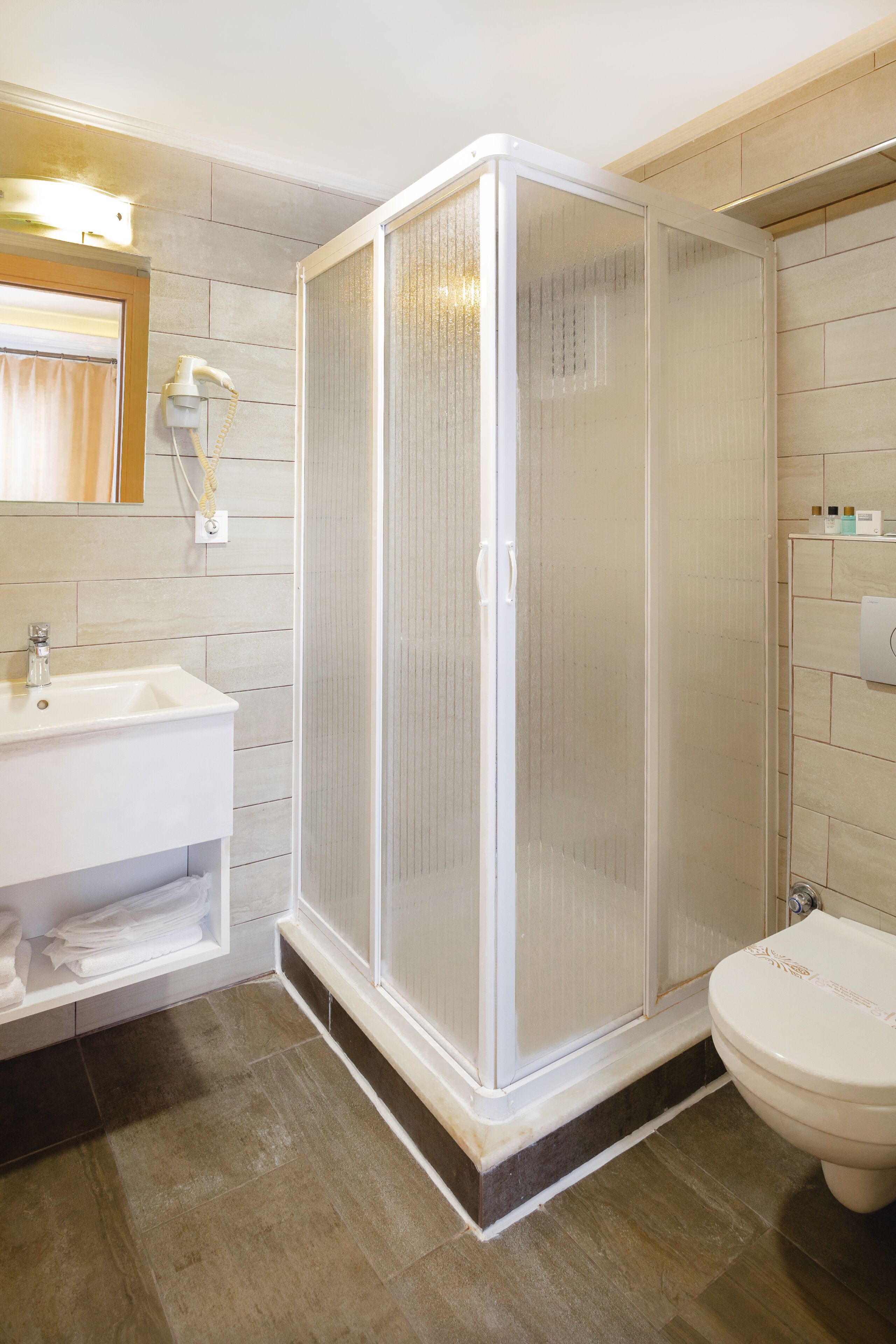 Standaard kamer | Badkamer | Een douche, een haardroger, pantoffels