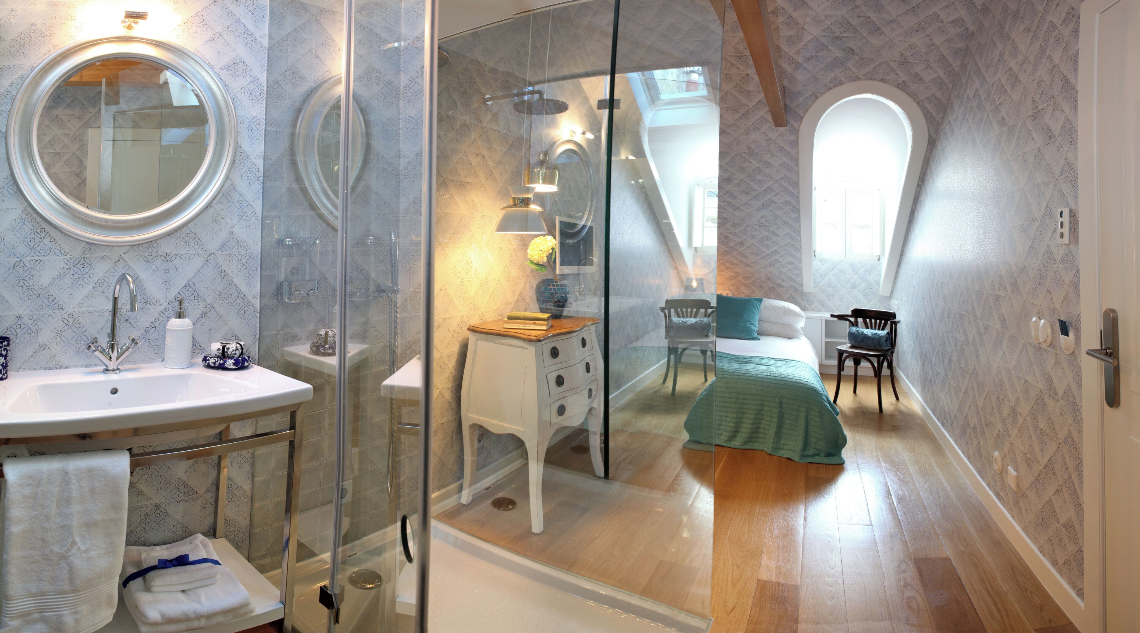 A bathroom with a sink, mirror, and shower.