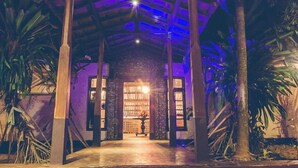An interior with a high ceiling, wooden beams, and a central doorway leading to another room. - Villa Birdlake (Hikkaduwa)