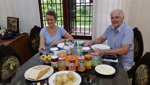 A dining table with plates of food, condiments, and utensils.