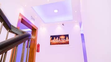 A staircase with a handrail, a ceiling with recessed lighting, and a framed picture on the wall.