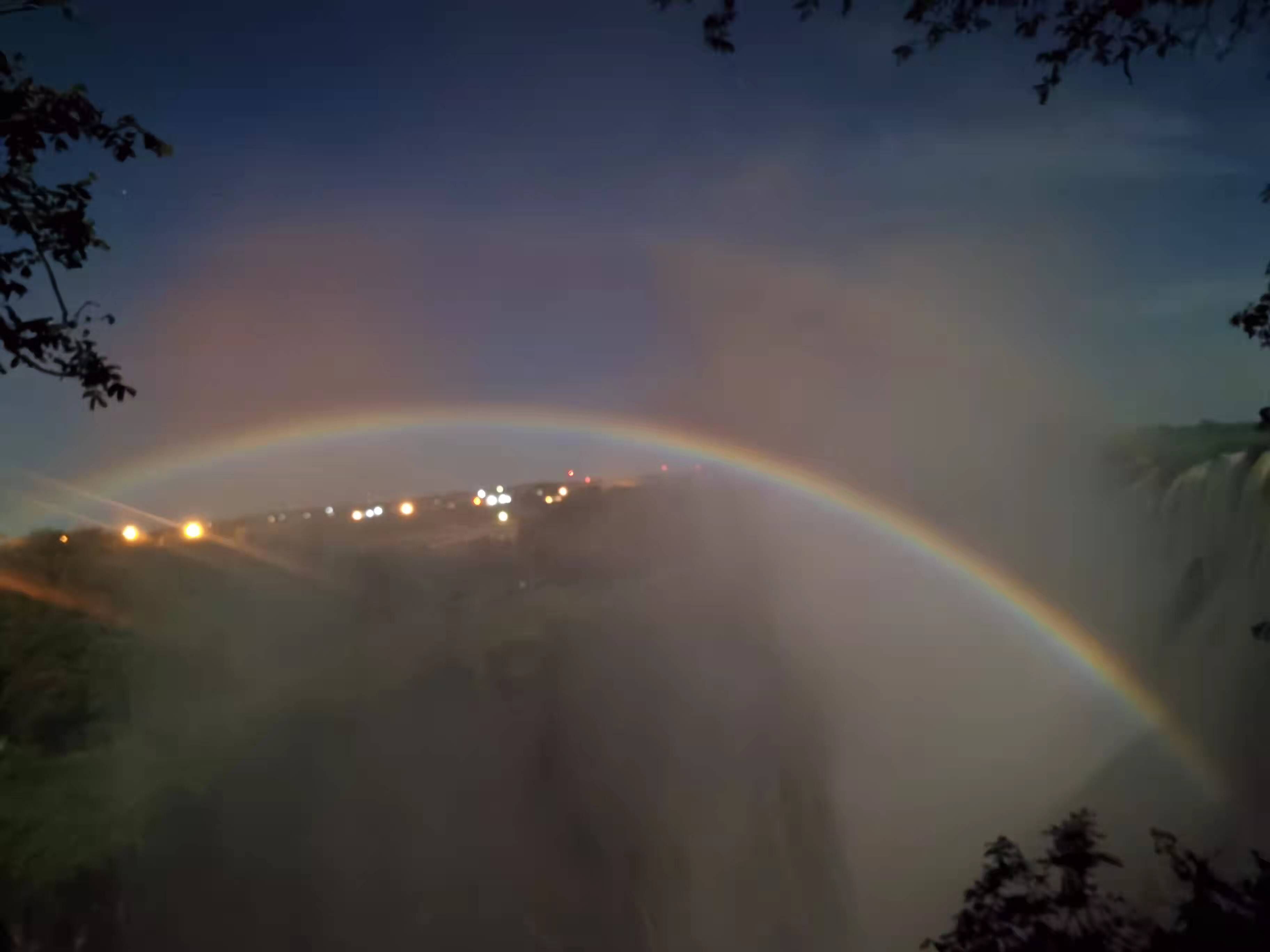 Ein Wasserfall mit einem Regenbogen darüber.