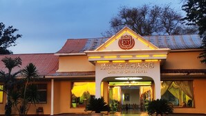 The Oriental Swan Hotel entrance with a sign, potted plants, and a tiled roof. - Oriental Swan Hotel Livingstone (Livingstone)