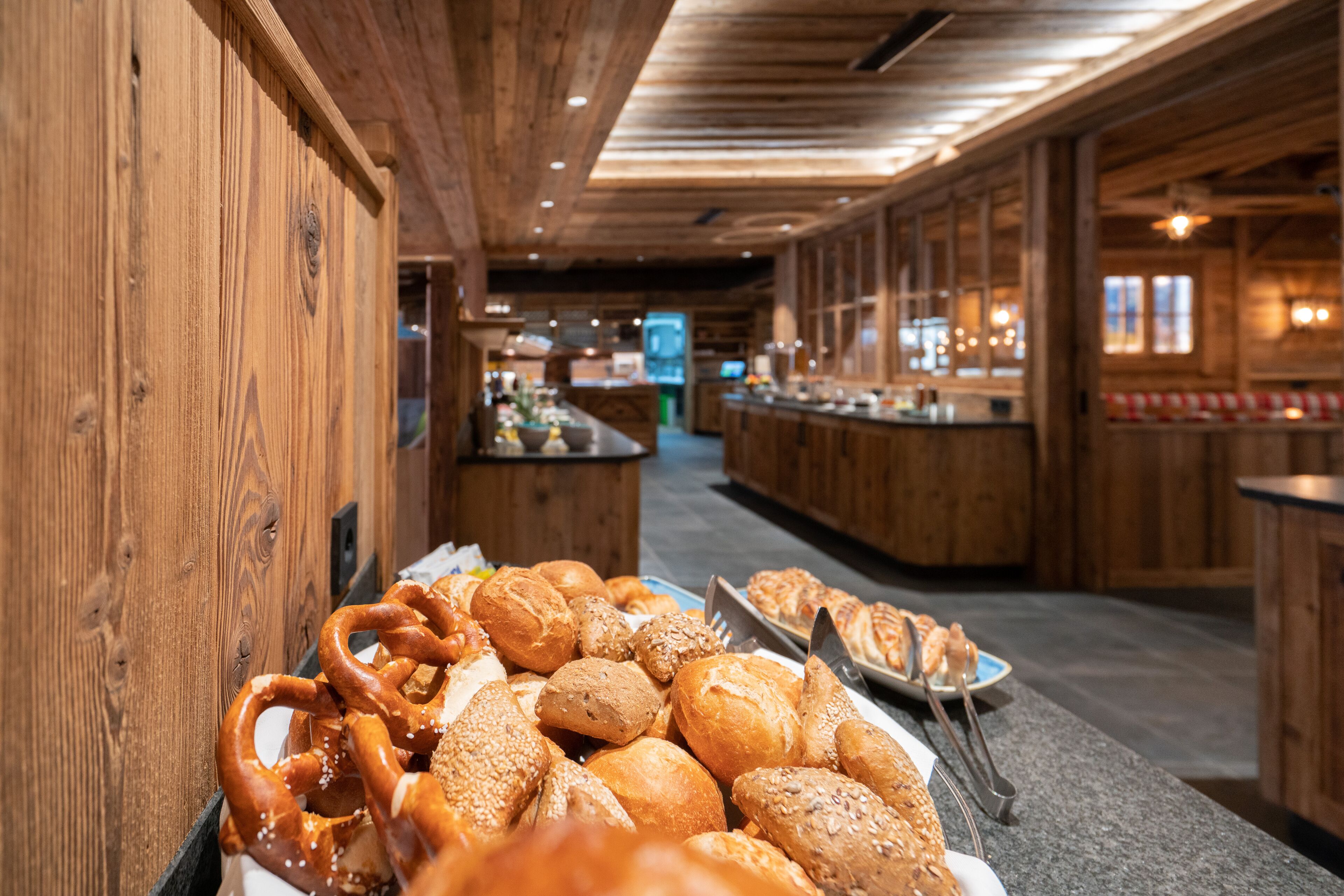 A buffet with various breads and pretzels.