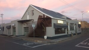 A building with a sloped roof, a sign reading "S-CAPE TOURISM ROUTE", and a gated entrance. - Melite Rooms (Cape Town)