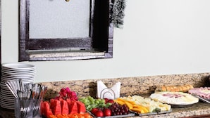 Un bufé con diversos alimentos, como frutas, verduras y carnes.