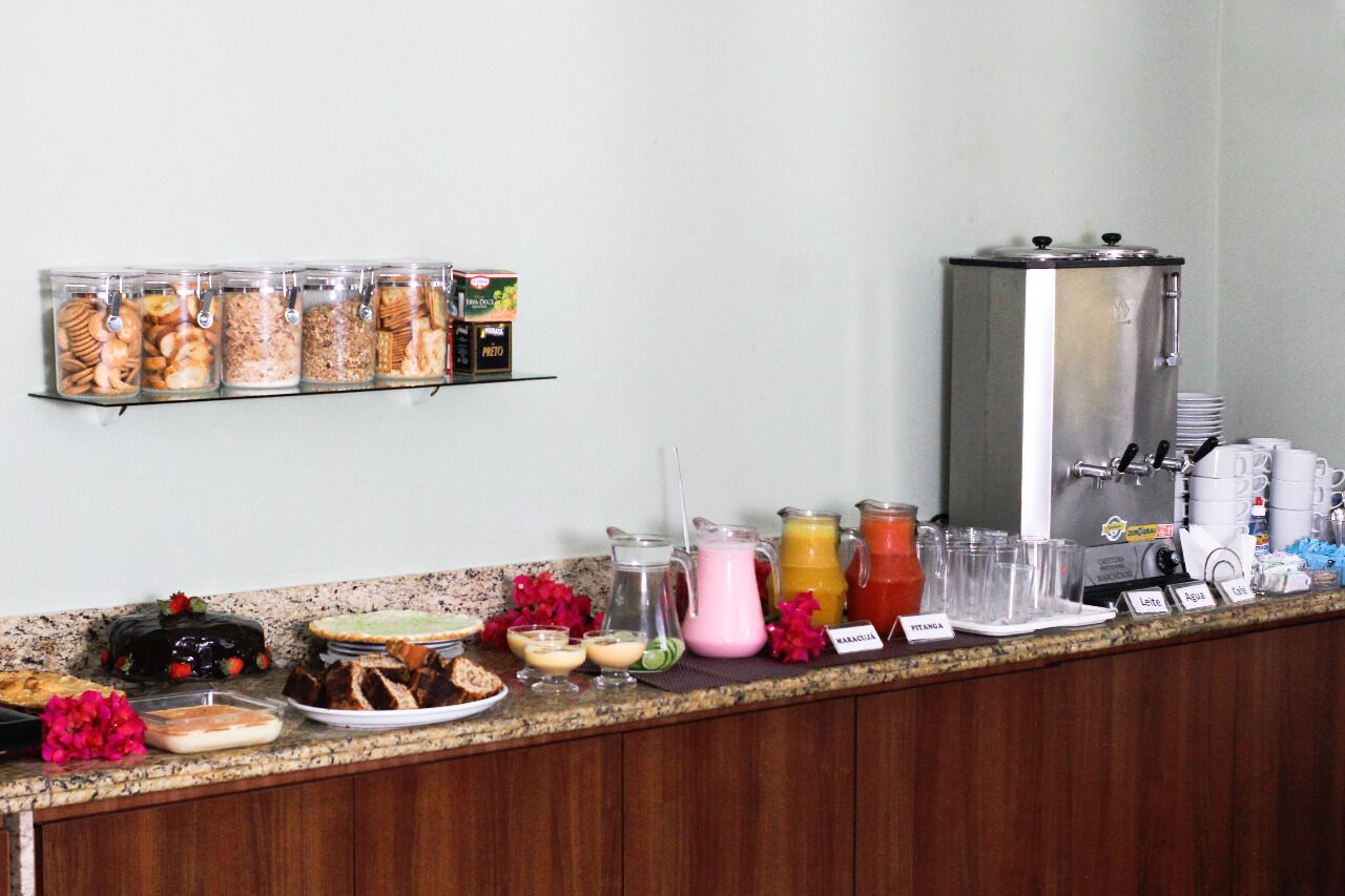 Una barra de desayuno con diferentes alimentos, bebidas y una máquina de café.