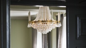 Un comedor con candelabro, sillas y una mesa.