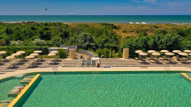 A swimming pool with a view of the beach and ocean. - Residence Solidago (Pisa)