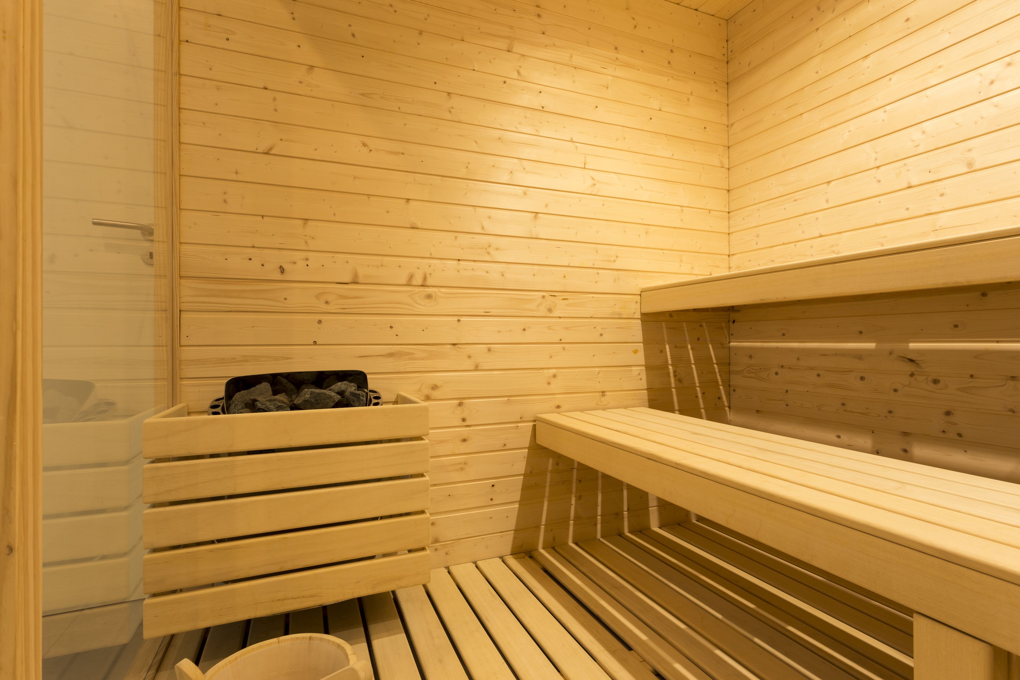 A sauna with wooden benches and a bench with a towel.