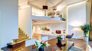 Ein modernes Interieur mit Essbereich, Treppe und Küche.