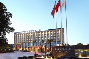 Un hotel con fachada moderna, varios pisos y una entrada destacada con un letrero.