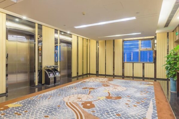 A modern elevator area with a patterned floor, a vending machine, and a window with a view. - East Harbour Hotel (Ningbo)