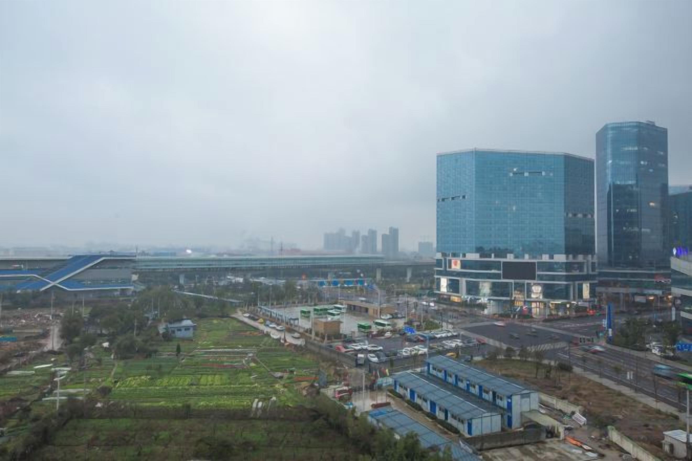 A cityscape with modern buildings, a bridge, and a mix of urban and green spaces.